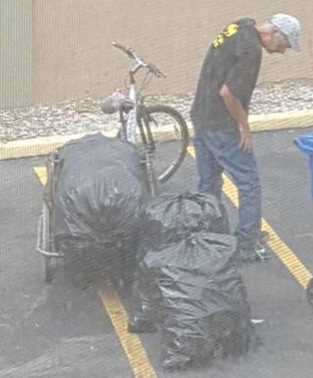 A nő megpillantja a rendőrt a férfival a kukáknál. Titokban lefotózza, mit művelnek